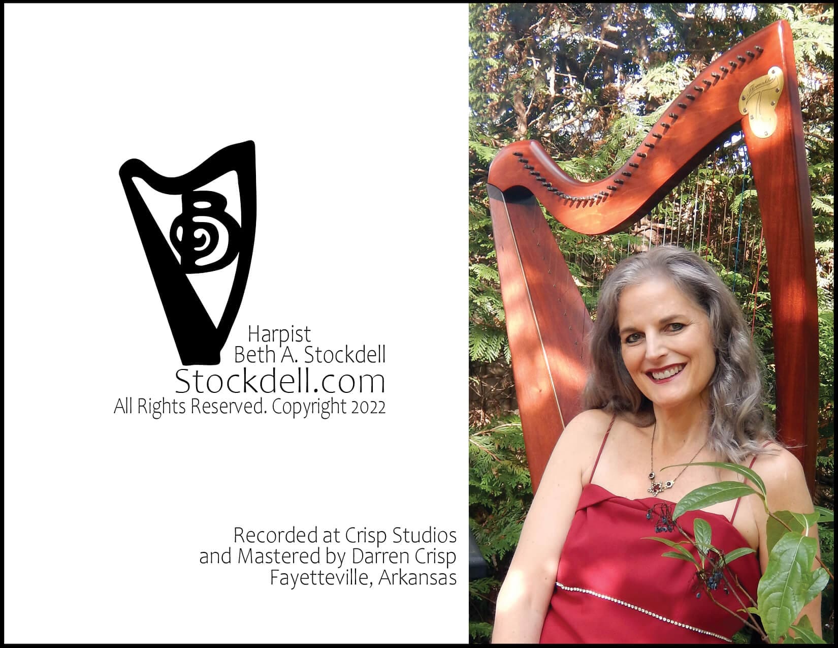 Woman playing harp outdoors in red dress.