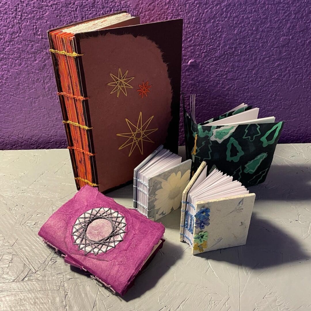 Handcrafted journals with star and floral designs.