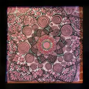 A pink and black mandala with circles on it