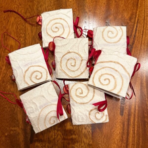 A group of six white boxes with red ribbons.