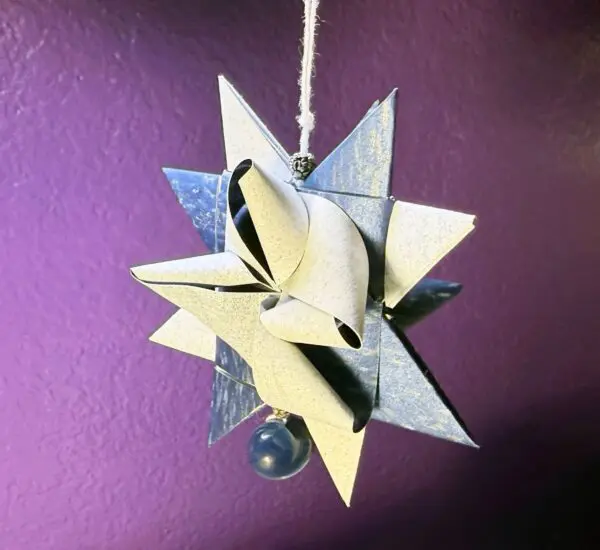 A star made out of paper hanging on a string.