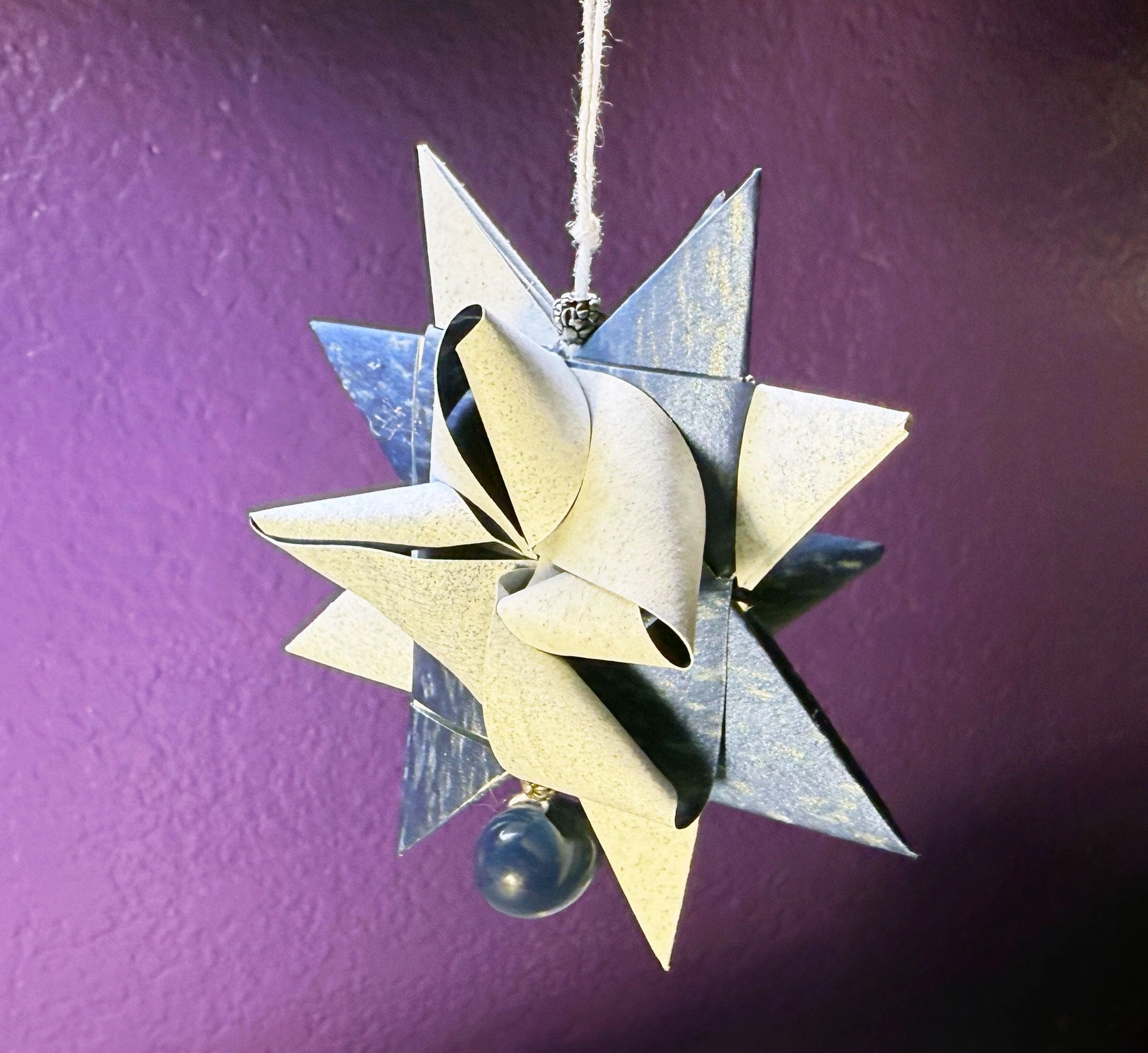 A star made out of paper hanging on a string.