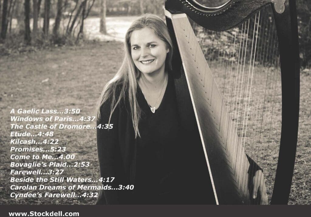 A woman standing next to a harp in the woods.